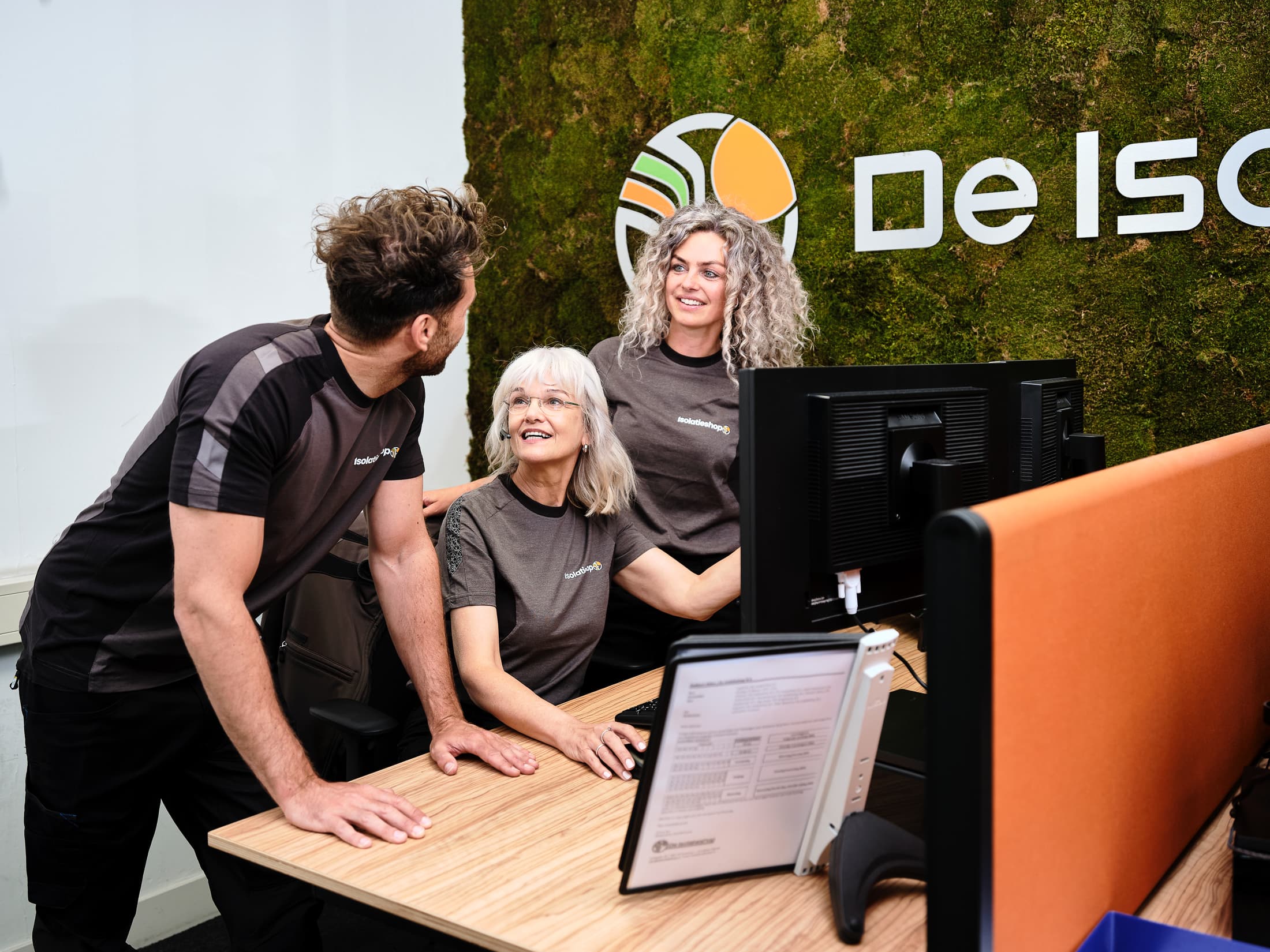 Verkopers van De Isolatieshop die overleggen achter een laptop